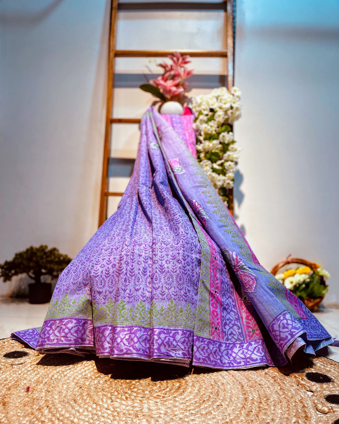 Purple embroidered fabric on a woven surface with a blurred background