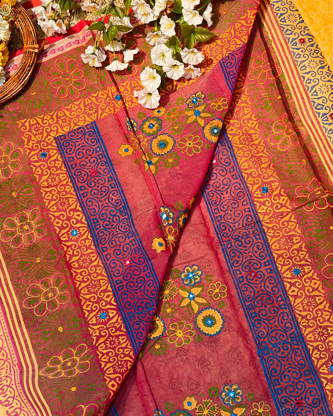 Decorative fabric with floral patterns and colorful borders on a yellow background