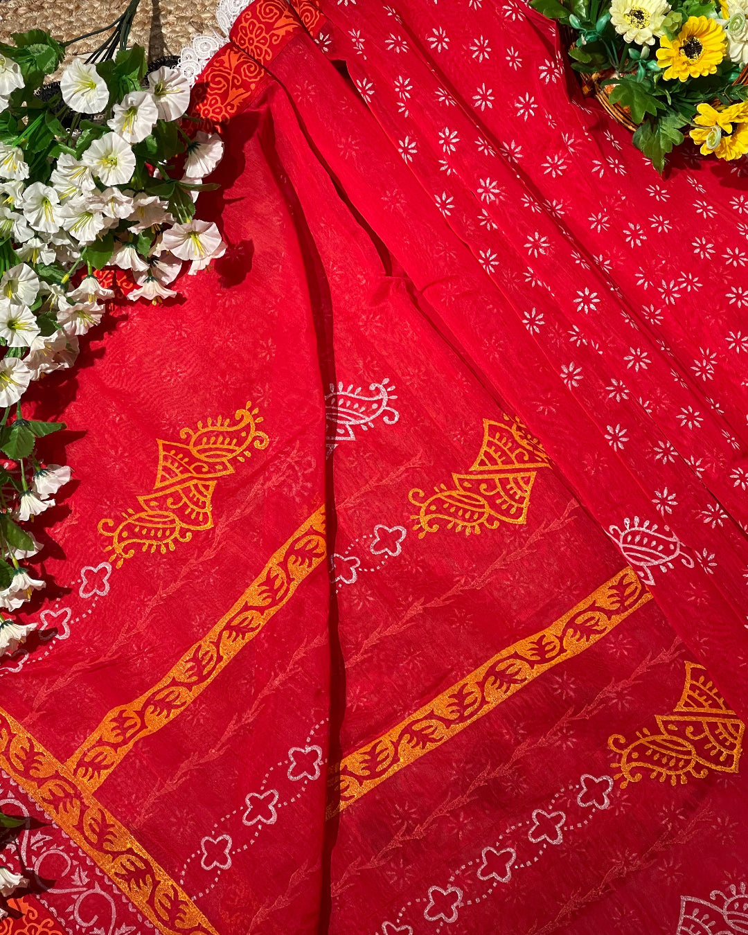 Red fabric with gold patterns on a floral background
