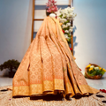 Traditional embroidered saree on a textured surface with decorative elements in the background