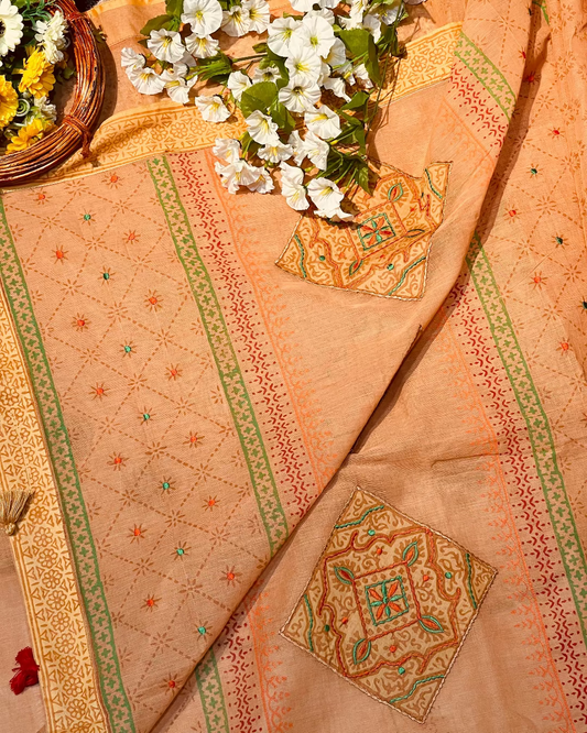 Decorative fabric with intricate patterns and a basket of flowers on a textured surface.