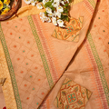 Decorative fabric with intricate patterns and a basket of flowers on a textured surface.