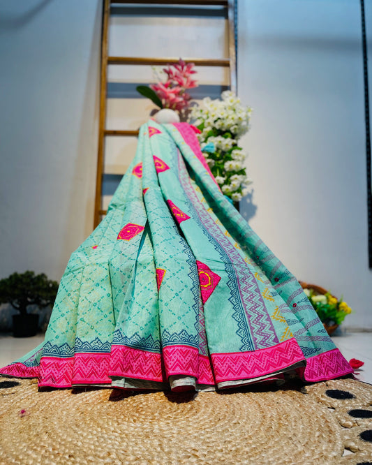 Colorful traditional fabric with pink and green patterns on a textured surface.