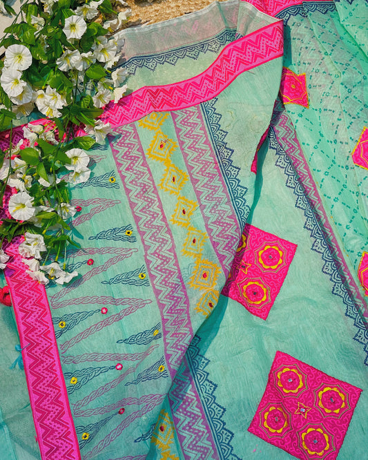 Turquoise fabric with pink and yellow patterns, surrounded by white flowers.