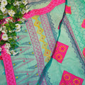 Turquoise fabric with pink and yellow patterns, surrounded by white flowers.