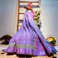 Purple embroidered fabric on a woven surface with a blurred background