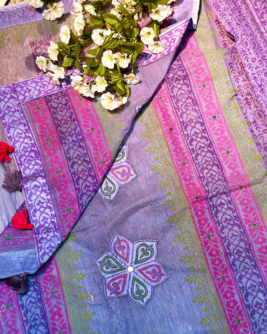Colorful fabric with floral design and embroidered patterns on a textured surface.