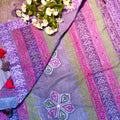 Colorful fabric with floral design and embroidered patterns on a textured surface.