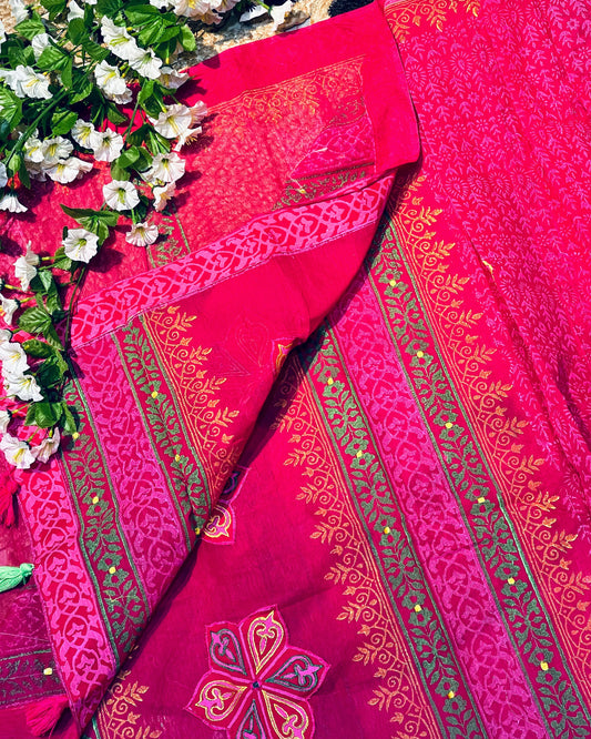 Red saree with intricate gold patterns on a floral background