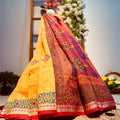 Two colorful sarees draped over a woven surface with flowers in the background