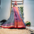Traditional saree with intricate patterns draped over a decorative surface