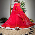 Red traditional outfit with white patterns on a woven mat