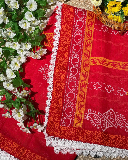 Red fabric with orange and white patterns on a floral background