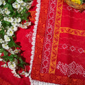Red fabric with orange and white patterns on a floral background
