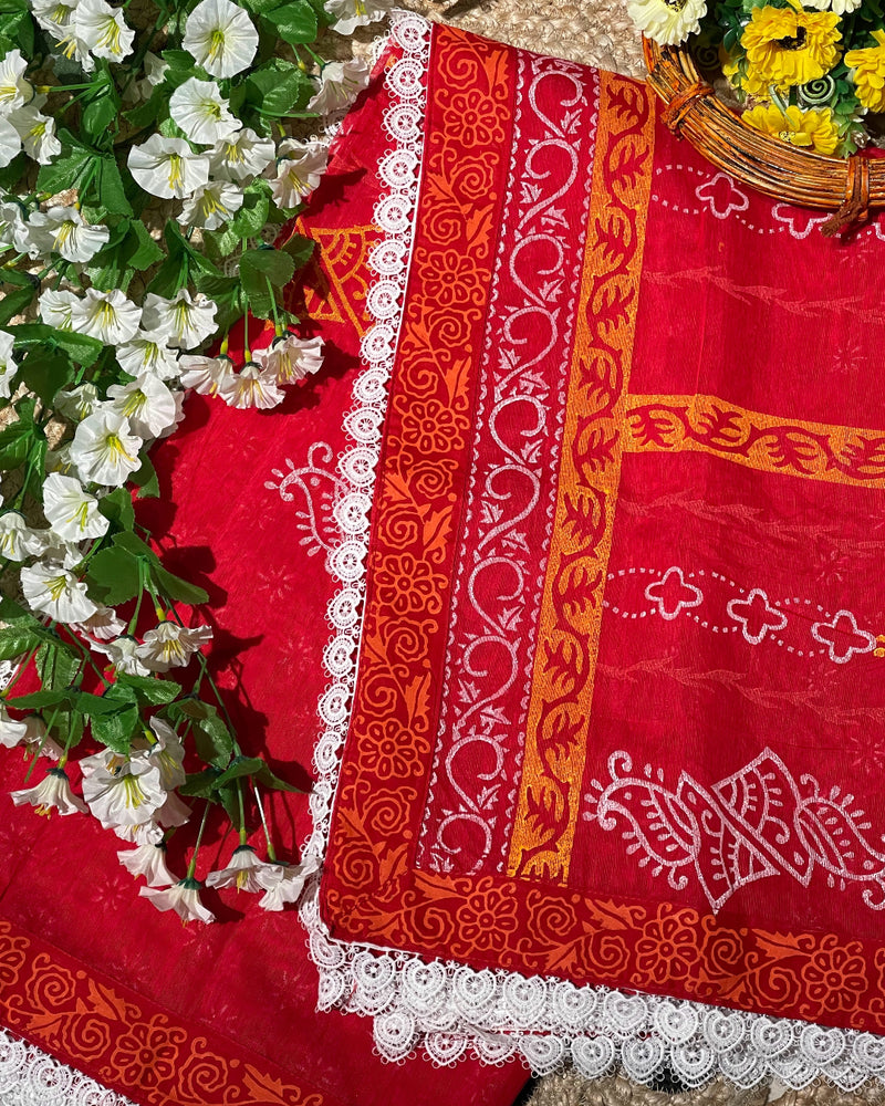 Red fabric with orange and white patterns on a floral background