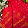 Red fabric with gold patterns on a floral background