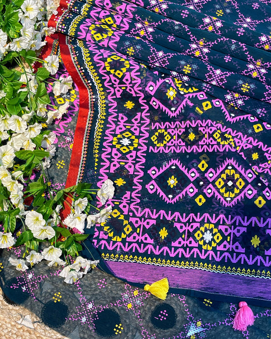Colorful embroidered fabric with geometric patterns on a floral background
