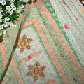 Decorative fabric with floral patterns and green leaves in the background