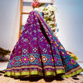 Colorful embroidered fabric draped over a wooden ladder with flowers in the background