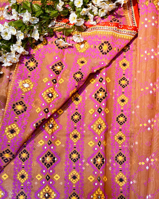 Decorative fabric with pink and orange patterns, surrounded by white flowers.