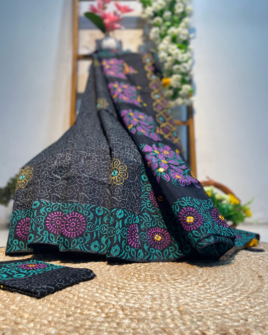 Black floral patterned fabric on a textured surface with flowers in the background