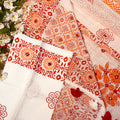 Patterned fabric with red and orange designs on a white background