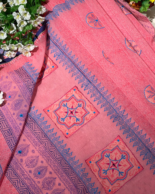 Pink fabric with blue and red patterns on a floral background
