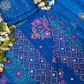 Blue fabric with intricate patterns and white flowers