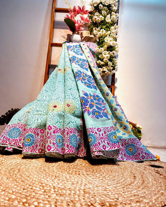 Colorful patterned fabric draped over a surface with flowers in the background