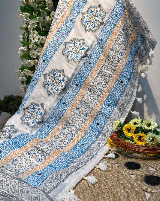 Decorative tablecloth with geometric patterns on a stone surface with flowers.