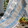 Decorative tablecloth with geometric patterns on a stone surface with flowers.