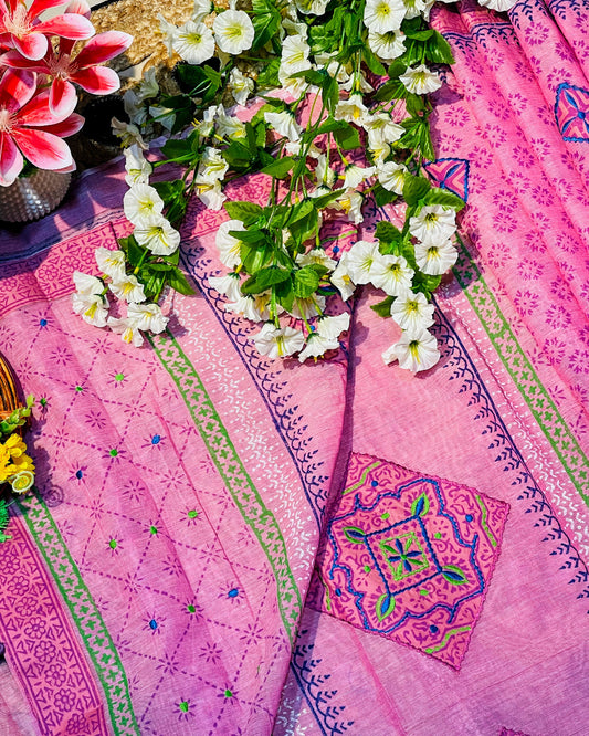 Pink embroidered fabric with white flowers on a colorful background